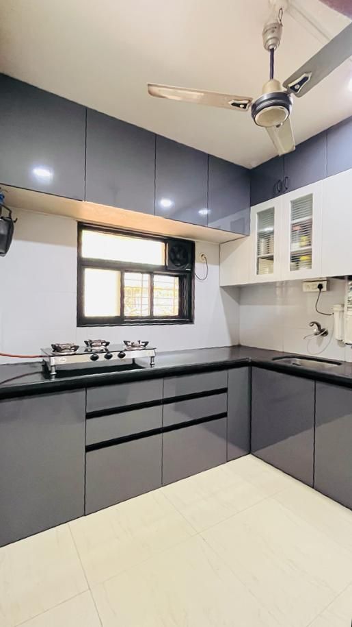 Modern kitchen design with wooden cabinetry by Elite Interiors in Hyderabad